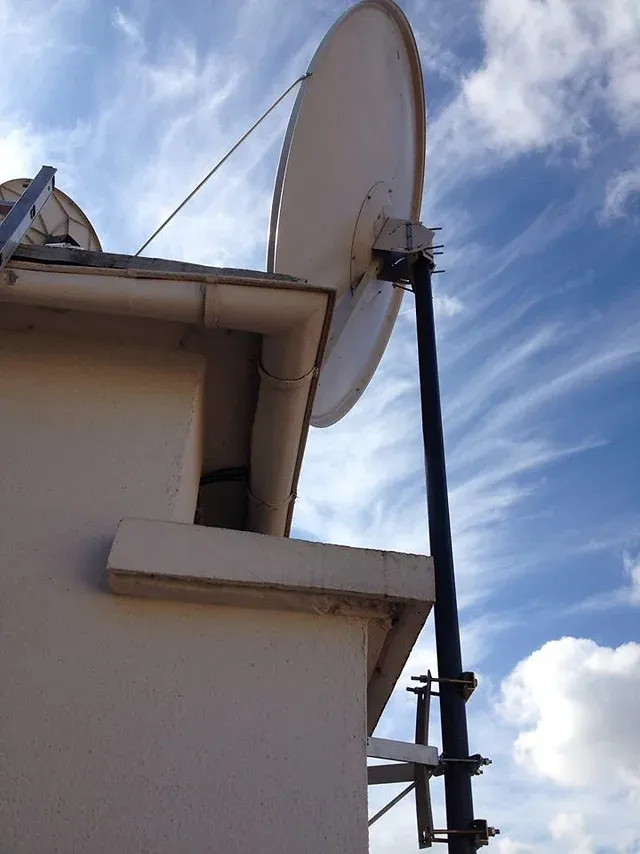 Technicien antenniste réglant une antenne TV