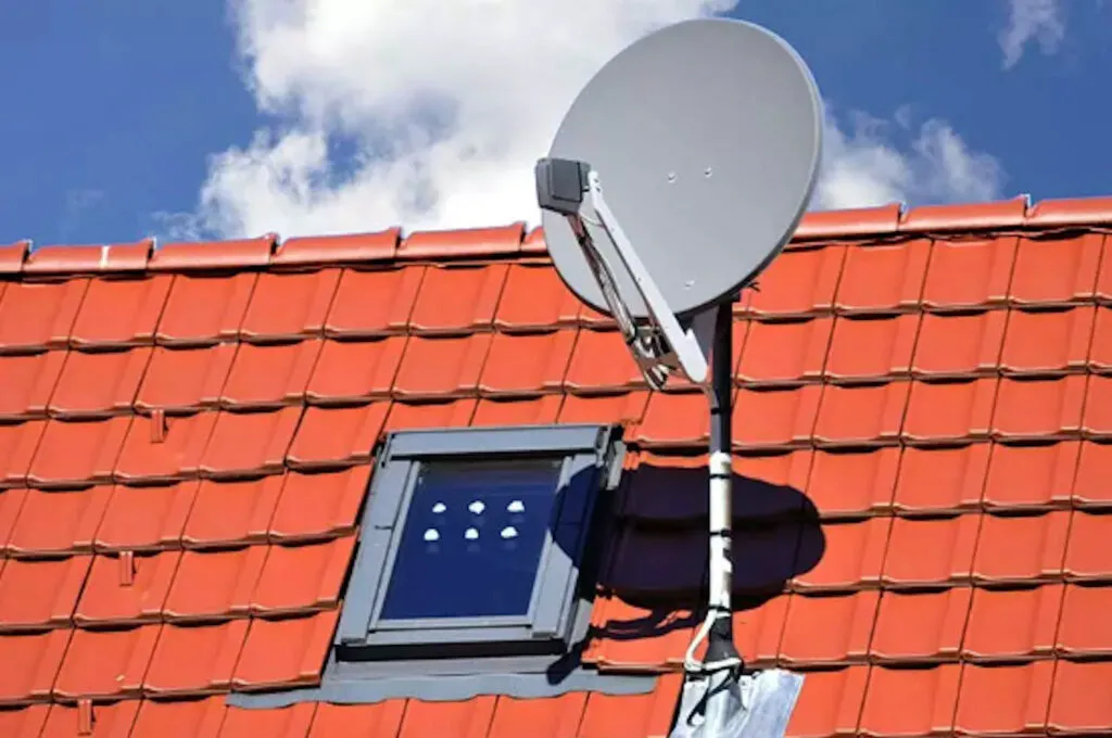 Technicien antenniste réglant une antenne TV